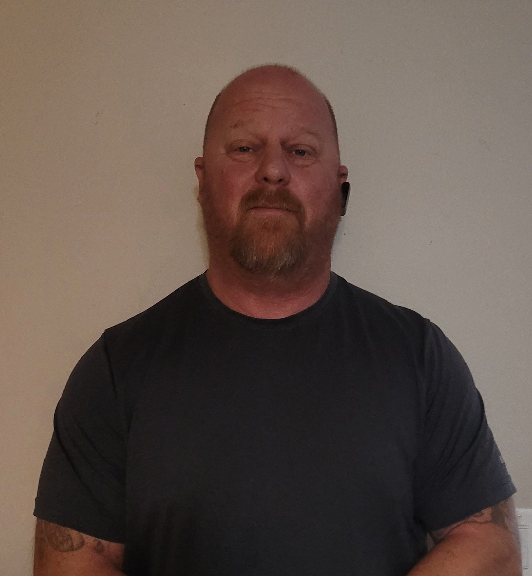 Portrait of a bald man with a beard wearing a black t-shirt.